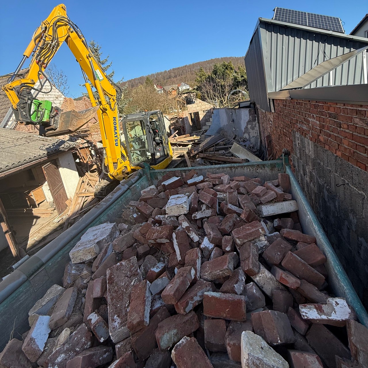 Abbruchmaterial und Bagger auf einer Rückbaustelle